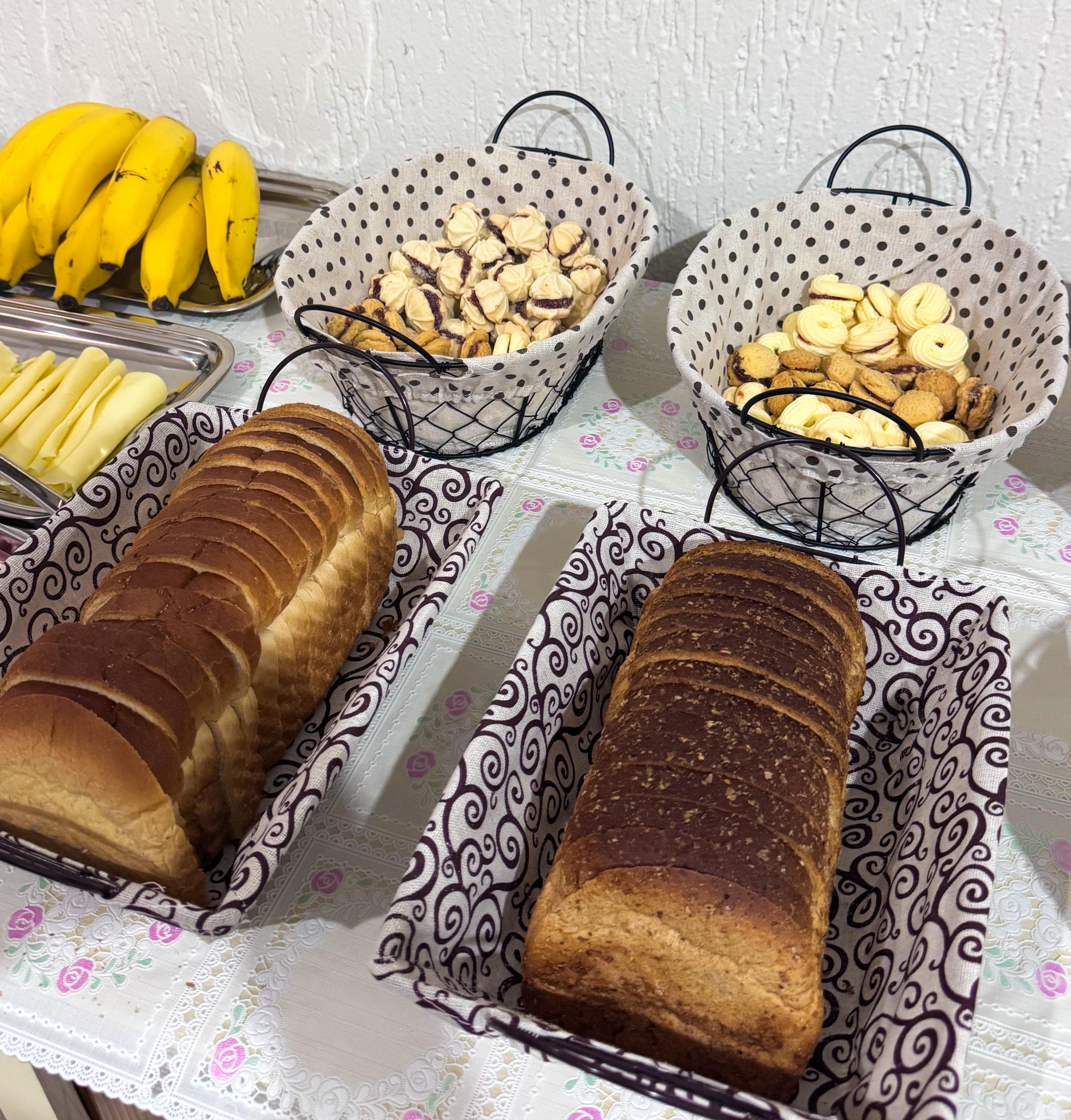 Cestas com pães de forma, biscoitos e frutas no café da manhã